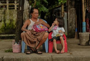 Grandfather and granddaughter waiting for school bus