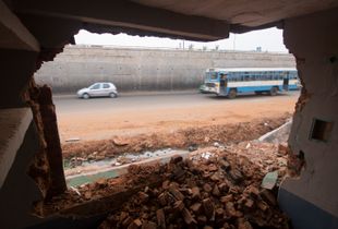 View of road traffic from inside a demolished home that was removed to make way for upcoming highway in Yelahanka, Karnataka, India