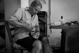 Grandad Francesco at work with his tool repairing a shoe.
