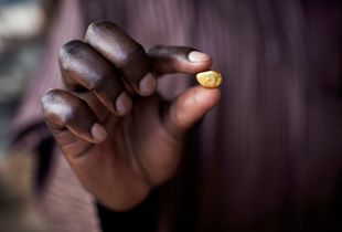 A gold trader is holding a piece of pure gold, extracted in Zamfara State, Nigeria. The contamination in artisanal gold extraction is caused by ingestion and breathing of lead particles released during the process of isolating gold from other metals. This type of lead is soluble in stomach acid and can lead to serious disabilities or death. © Alex Masi