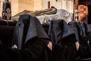 Participants carry the body of Jesus out of the church, partially on their knees.