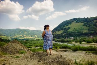 Elder woman looking over the River Viseu on the outskirts of the small village Ruscova in  Maramures.