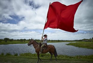 Gaucho flying the Gauchito Gil red coloured flag in the El Yaguarì estancia in Curuzù Cuatià village