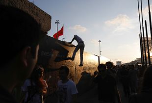 A protester tries to jump over the fence of the former Atatürk Cultural Center during a demonstration in Taksim square in Istanbul on Saturday, June 8 2013.