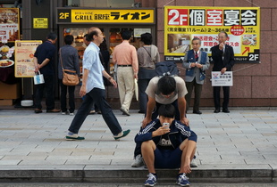 Chinese father and son seriously looking into the same small screen  on smartphone