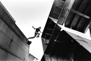A young man is jumping on top of structures at an abandoned ships graveyard, Kronstadt Naval Base, Russia, May 2005