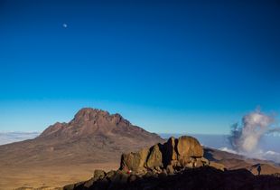 African woman farmers and the last warmth of sun at the base of Mount Kilimanjaro's Kibo Peak's summit climb.