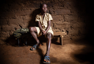 Aimable seating at his house in Nyakabiga neighbourhood, Bujumbura, Burundi.