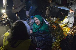 Rescue workers try to warm a Syrian woman suffering from severe hypothermia after a boat landing on Lesbos. March 20, 2016.