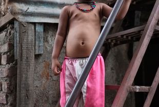 Child on the stairs to their home, Dharavi