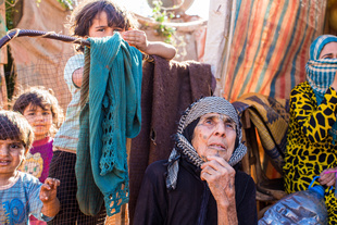 Bekaa Valley, LEBANON, September 5, 2014: Syrian refugee Aida el Issa (79, center), and her grandson Amjad (7, center left) fled from Syria over night three years ago, when news occurred that their village was going to be bombed. They don’t know what happened to their house since then.