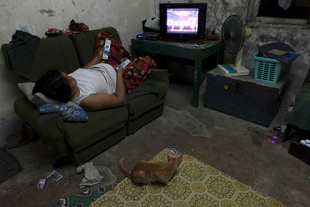 Working from home mom watch TV at her rest in Yuzana Garden City, Yangon, Myanmar.
