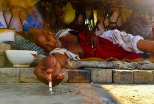 He took a little snap with his cigaret at his street home.