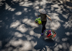 Woman in Hanoi, wandering the streets selling vegetables.