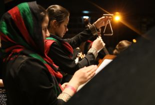 Back of the stage, the young percussionists under the lights.