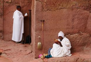 Men reading the Bible in front the church