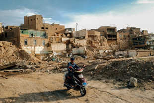 A motorist ride past the original of old city of Kashgar before it was demolished by local authorities.