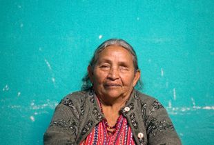 Juana Buch Chumil sees with only one eye as she didn't have money to save her left eye when it started to lose light. Juana lives with her daughter and two grandchildren. The bed she shares with grandchildren has no mattress. The poorly constructed roof made of lamina leeks water and it turns dirt floors to mud when it rains. Juana experiences vomit and dizziness regularly. Though, she is the onl