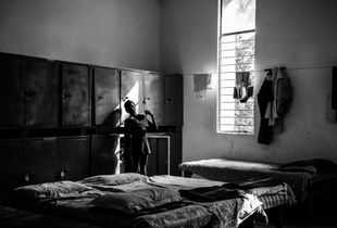 A visually impaired boy wears his clothes as he gets ready for school in a boarding facility school for blinds in Delhi.