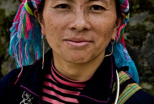 H'mong Lady wearing the traditional  brightly coloured scarf wrapped around her head and heavy silver jewellery.