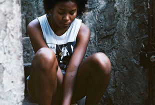 Thay sitting in her street in  favela Vila Cruzeiro.