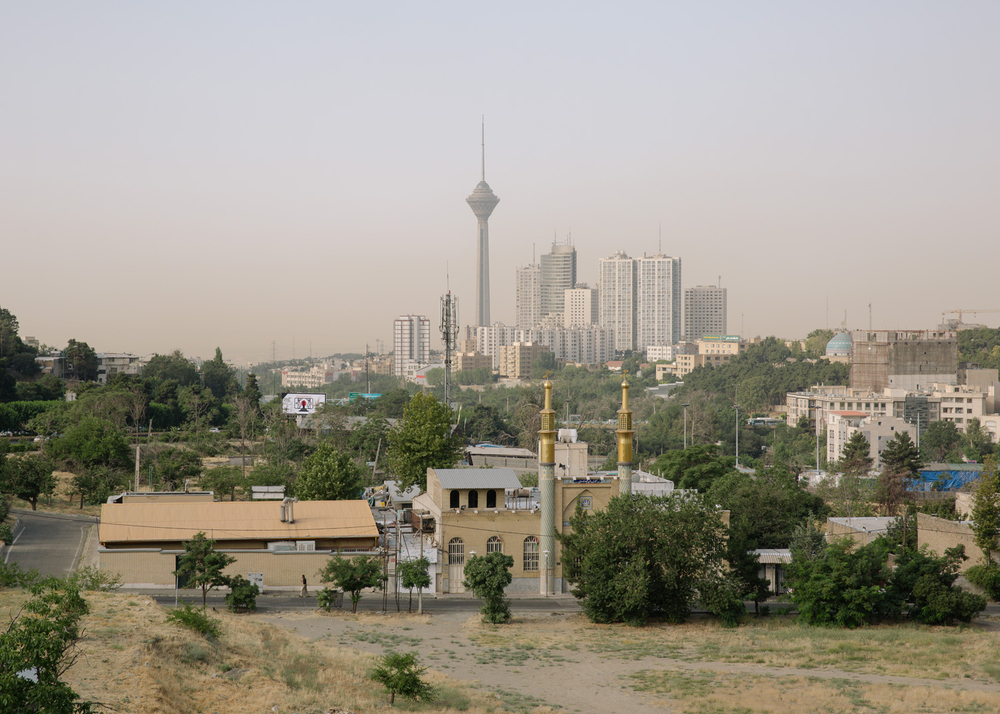 Human and mosques in the cityscape of Tehran