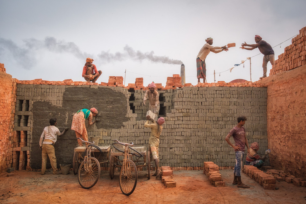 Another brick in the wall. People working in a brick kiln in the suburbs of Dhaka, Bangladesh, February 2024. © Nicolas Monnot
