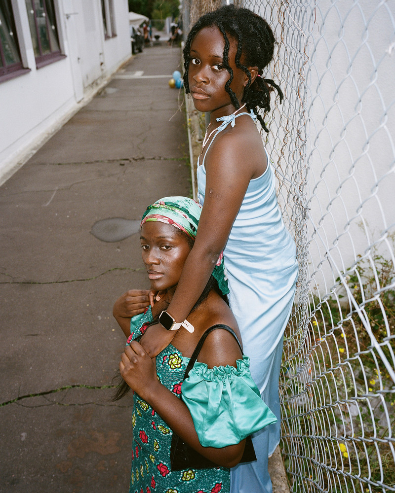 Anais and Jannai. On the outskirts of Frankfurt, an industrial area transforms every Sunday as diverse faith communities find solace in affordable, quiet spaces. Hidden within plain warehouses, independent churches and cultural associations thrive, hosting prayers, weddings, and gatherings. Surrounded by office buildings, repair shops and one of Germany's largest meat producing factories, these small communities remain unnoticed by much of the city. In contrast to prominent institutionalized churches, they quietly foster connection and tradition among themselves. © Josefine Rauch