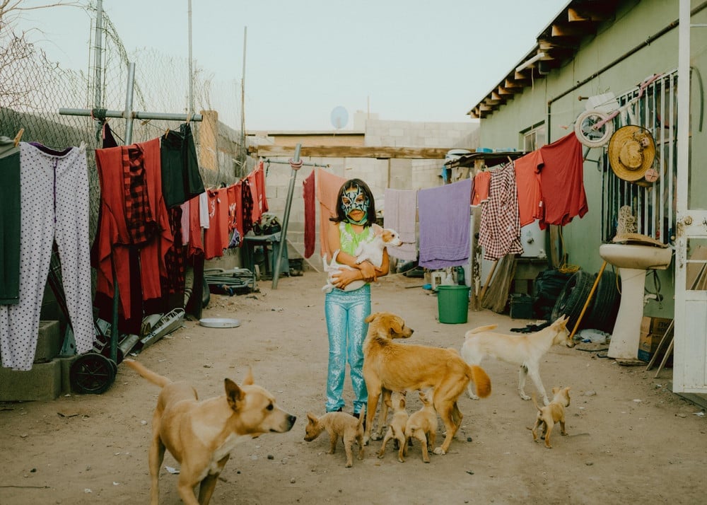 At Home. Atziry in the courtyard of her home. The streets are not safe for women in Juarez. And although the home is considered a safe place, Jatziry is calmed by the presence of the seven dogs. © Jana Margarete Schuler