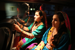 Girls dressed with their scene dresses on the bus to the concert hall.