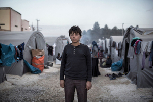 Syrian Kurdish boy from Kobane stands for a photo in the 'Rojava' refugee camp in the border town of Suruc, Sanliurfa province on November 10, 2014.