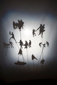 Drifting…, installation, 2016, variable dimension10 giclée prints 10 x 15 cm on aluminium, white curtain, shadow installation, cardboard silhouettes, wooden sticks, projector