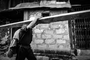 A man carrying materials for rebuilding houses destroyed by the 2015 earthquake. Barpak, Gorkha District.