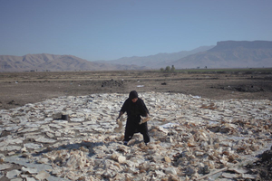 A Kurdish woman drying wet breads after last night’s rain