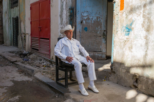 Back in the early days of the revolution, he had been a guerrilla lieutenant in the mountains with Castro. Now retired, he sits in the  in the front of his house in downtown Havana on a Sunday morning surveying the street.