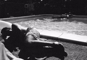 Alessandro relaxes in the pool side, on the back Bruno and his mattress.
