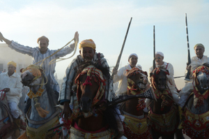 A rider tentatively holds his musket after its fall in a ride. Seffrou , Morocco