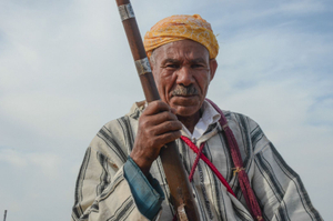 A rider , brandishes his musket as the sorba corral ahead of their charges. Seffrou, Morocco