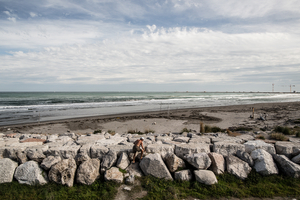 A man climbs over the final stretch of the murazzi wall on the Pellestrina island on September 27, 2012. The tip of the island breaking into the reinforced inlet has seen massive deposits since the inlets were reinforced. The sandy corner of the island became a safehaven for birds, and later officially named a bird sanctuary.