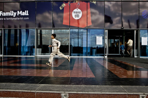 A Kurdish boy runs in front of the entrance of the Family Mall, the biggest mall in Erbil. © Tom Verbruggen