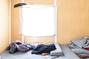 A sleeping infant barely protected from the searing sun in a prefab in Zaatari RC. © David Brunetti