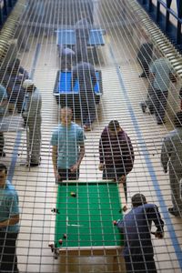 Prisoners play pool and socialise during a recreation period on C wing at the Young Offender Institution, Aylesbury, United Kingdom.