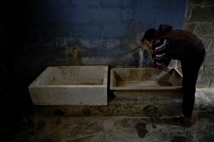 A boy washing his face at the camp's sanitational facilities. © Tom Verbruggen