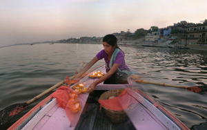 The girl who sells "diya" lanterns from her pink boat.