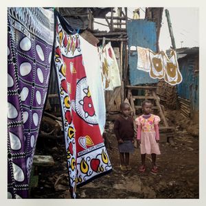 Children stand near clothes hanging on a washing line in Kibera. The Kibera slum is the largest slum in Nairobi with around half a million inhabitants.