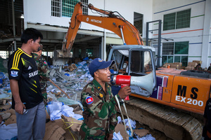 Cambodian armed forces search through the rubble for survivors after a building collapsed at Wing Star shoe factory killing two.