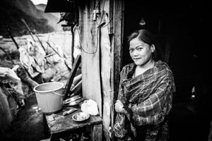 A resident of the village of Baluwa, Gorkha District, in front of a temporary shelter in which she is living with her parents, two sisters, and grandfather.