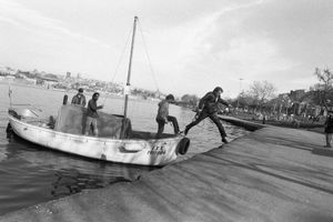 A man jumps from a small fishing boat onto the shore of Golden Horn.