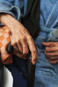 My father's hand resting on his walking cane.