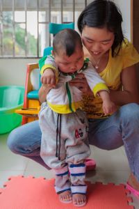 Feng receives daily physical therapy sessions and, despite suffering from cerebral palsy and autism, has been able to stay at home with his parents, who provide around-the-clock support and attention.